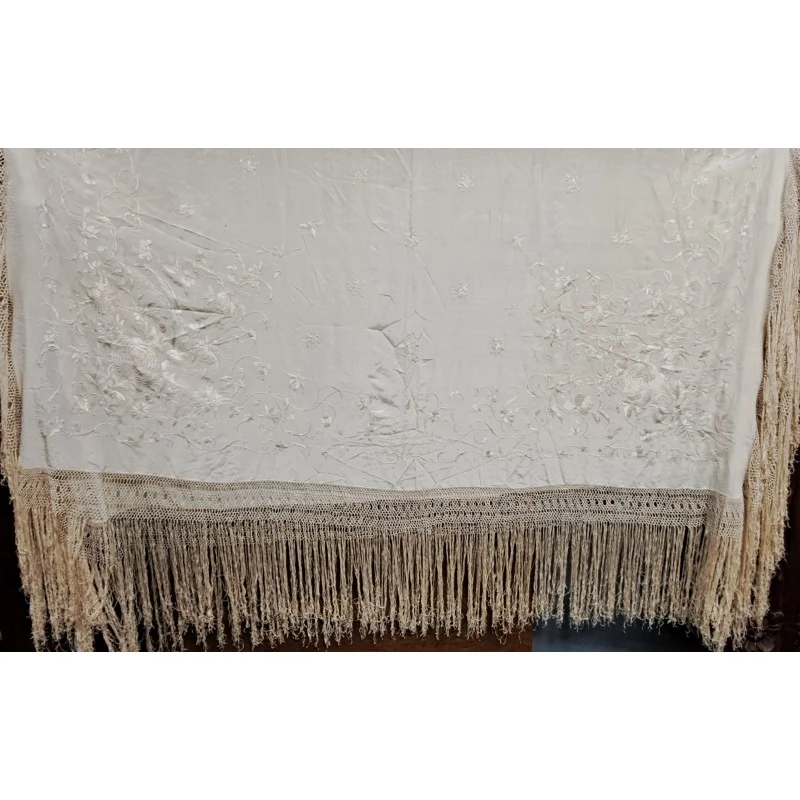 Mantón de Manila en seda marfil bordada con flores y flecos anudados